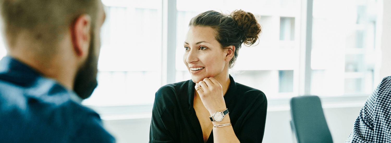 Smiling businesswoman with male coworker in meeting at workplace